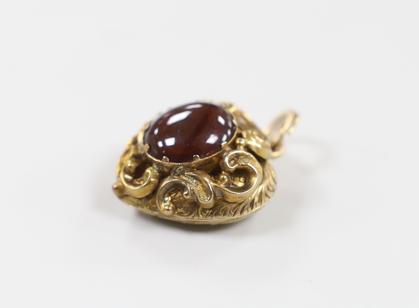 A Victorian yellow metal and cabochon garnet set heart shaped pendant, with glazed back, 21mm, gross weight 6 grams.